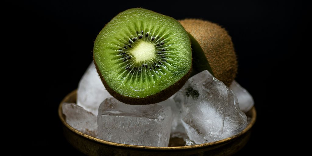 a kiwi cut in half sitting on ice
