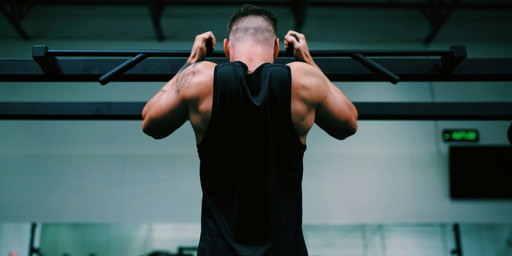 man in black tank top raising his hands