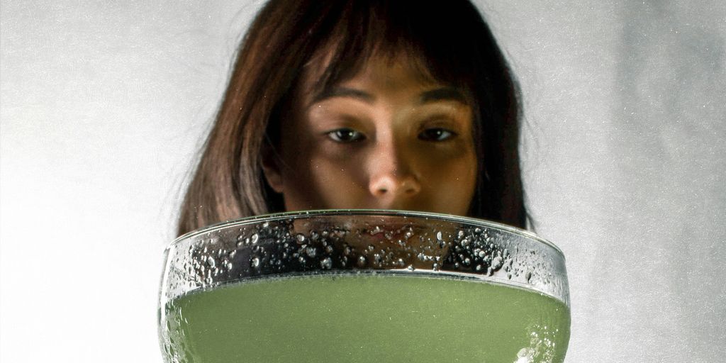 woman in white shirt holding green ceramic bowl