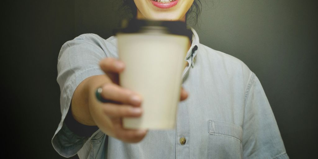 woman holding white and black coffee cup